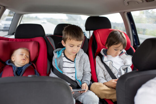 Three children, boys, siblings, traveling in car seats Kinder im Auto